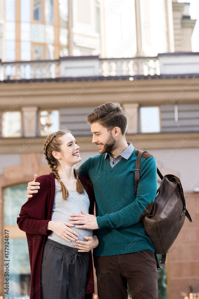 man touching belly of pregnant wife