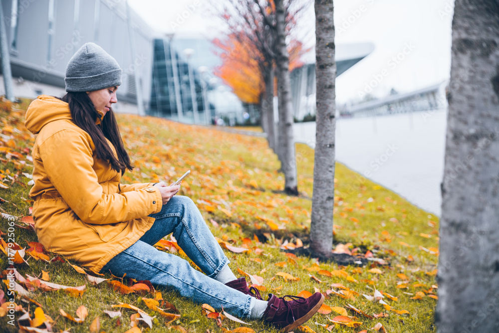 woman sitting on the ground under yellow trees woman sitting on the ground under yellow trees