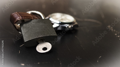 Lock with key on wristwatch concept of importance of time