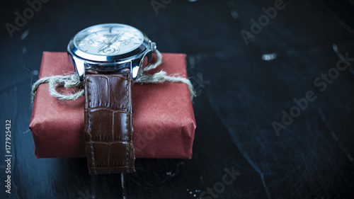 ..Gift watch  on a dark background concept of a holiday