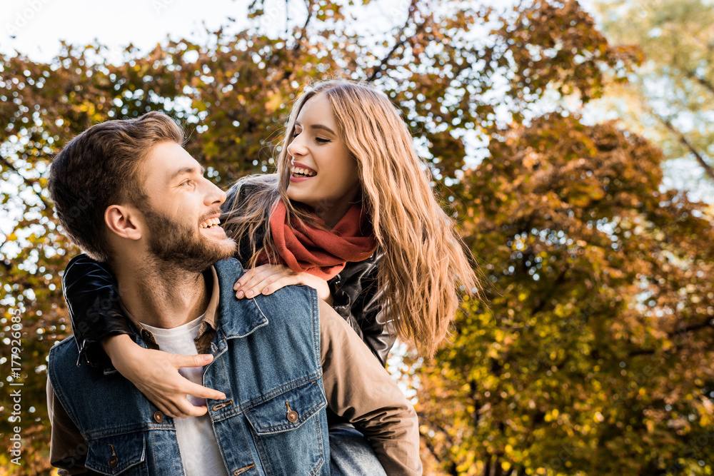 Fototapeta premium couple piggybacking in autumn park