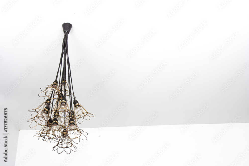 Obraz premium Cloase up wall lamp in modern design hanging from white ceiling.