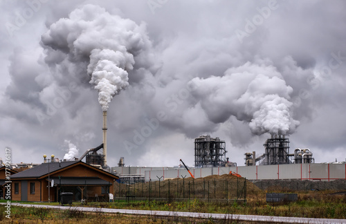 Atmospheric Air Pollution From Industrial Smoke Now. Pipes Steel Plant. Thick Smoke and Steam of MDF Production. Works in Cloudy Rainy Day. Environmental pollution.