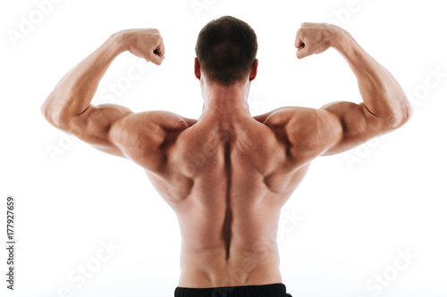 Photo of athletic young man showing his back and biceps muscles