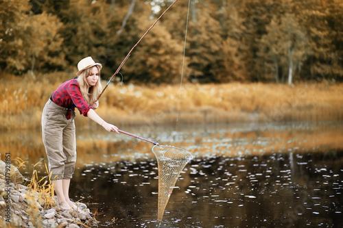 Girl in autumn with a fishing rod