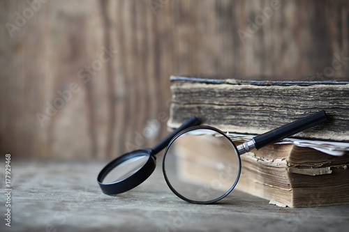 Φωτογραφία Old books on a wooden table and magnifier