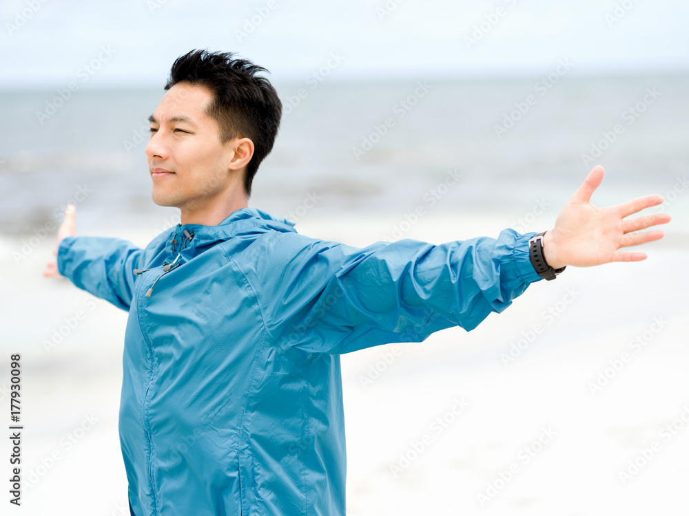 Young man with outstretched arms at the beach Young man with outstretched arms at the beach
