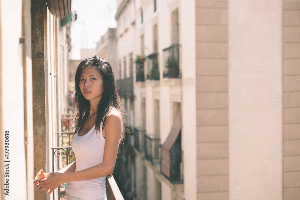 asian woman eating breakfast on the balcony in barcelona asian woman eating breakfast on the balcony in barcelona
