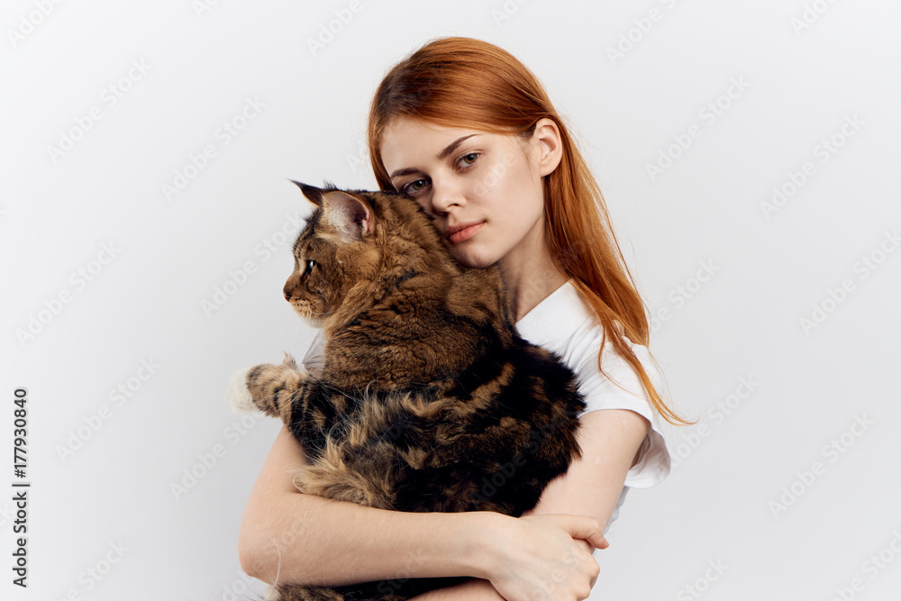 woman hugging a fluffy cat on a white background