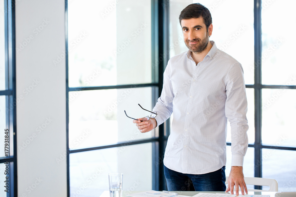 Young caucasian businessman standing in office Young caucasian businessman standing in office