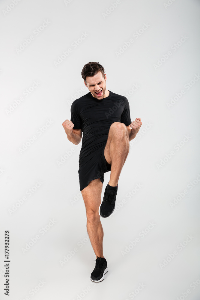 Full length portrait of a joyful excited sportsman jumping