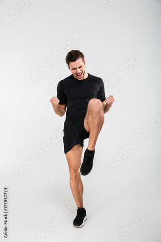 Full length portrait of a joyful excited sportsman jumping