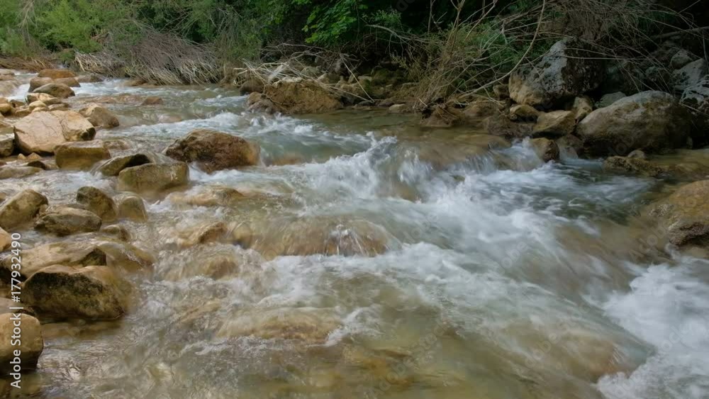 Rushing bubbling water of a mountain river. Spring rill flow. Nature composition. Rushing bubbling water of a mountain river. Spring rill flow. Nature composition.