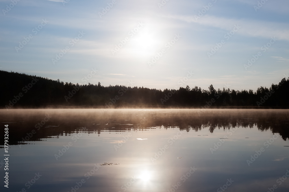 The mist hangs in the morning over the lake