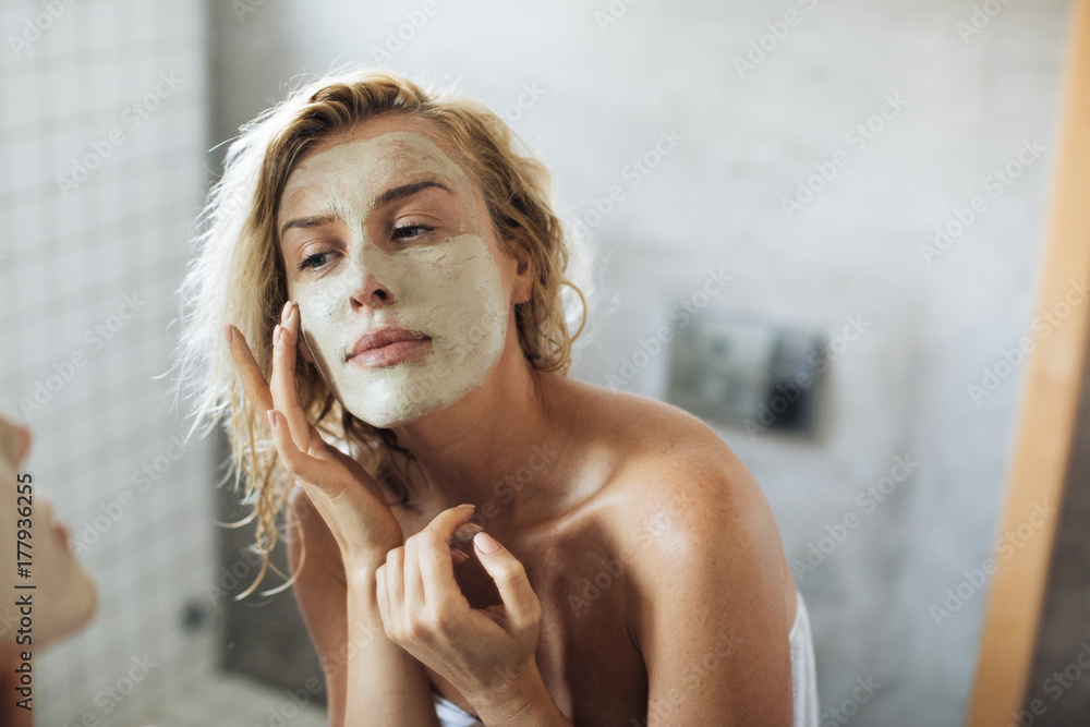 Woman Applying Face Mask - obrazy, fototapety, plakaty 