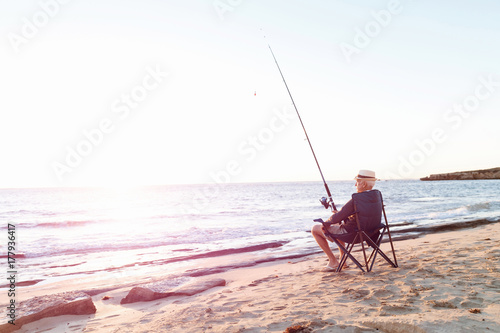 Senior man fishing at sea side