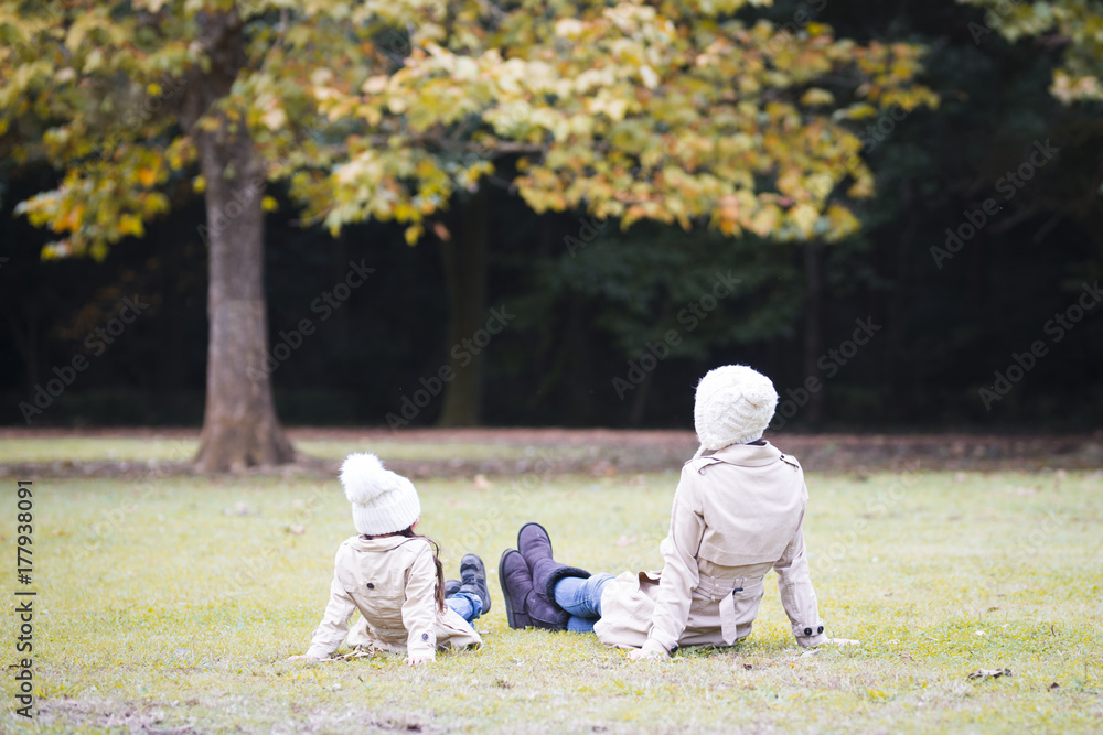Fototapeta premium Mother and daughter playing in autumn park