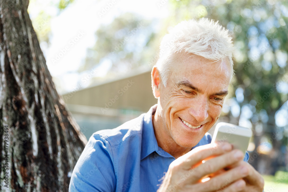 LoMature man outdoors using mobile phone LoMature man outdoors using mobile phone