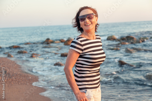 portrait of a stylish attractive mature woman 50-60 years on the seashore  travel and retirement  fashion and beauty