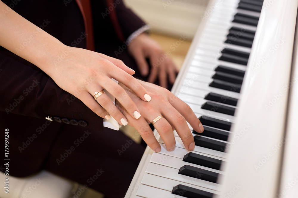 Obraz premium The bride and groom in playing the piano
