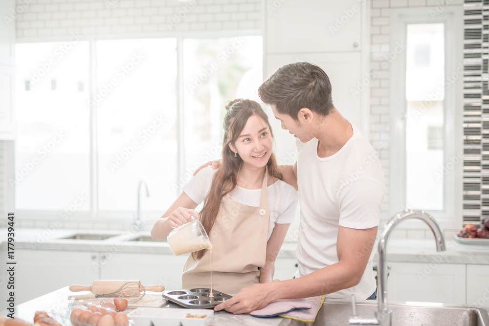 Fototapeta premium young Asian couple happy loving couple bakers helping to make dinner