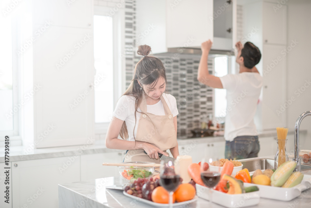 young happy couple cooking together in the kitchen at home. young happy couple cooking together in the kitchen at home.