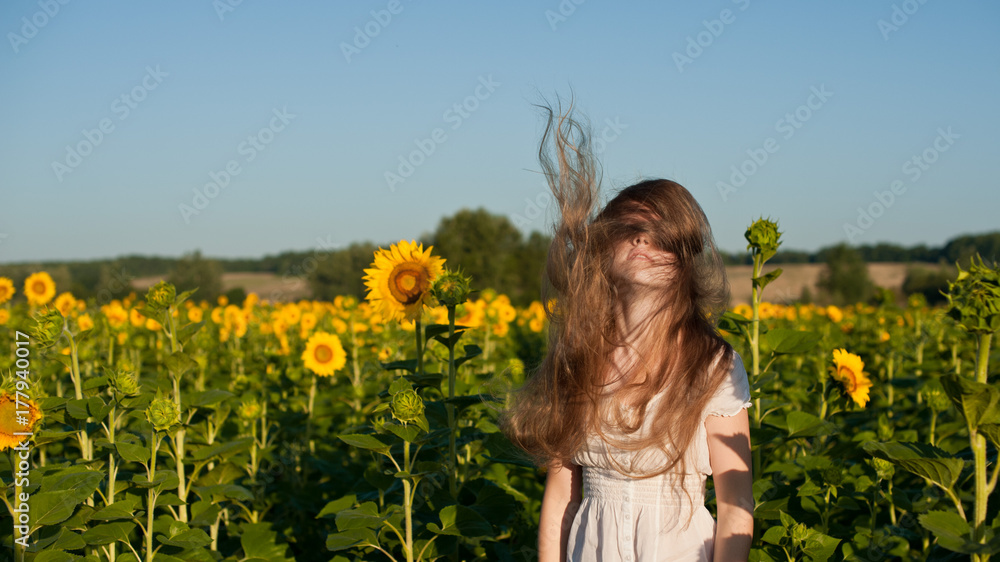 Girl with blond hair in a field of sunflowers Girl with blond hair in a field of sunflowers