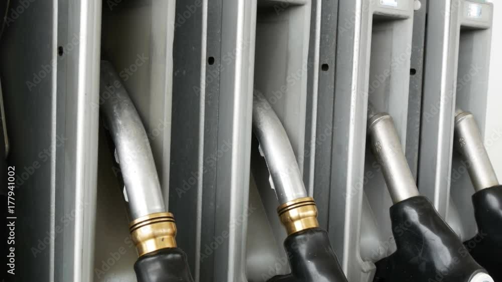 Different guns for pouring gasoline hang in row at the gas station.Gasoline or petrol station gas fuel pump nozzle Different guns for pouring gasoline hang in row at the gas station.Gasoline or petrol station gas fuel pump nozzle