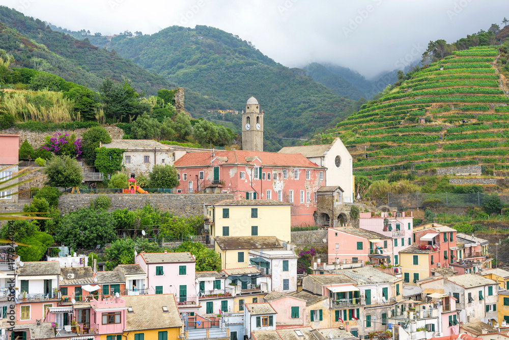 View to city, belltower of the church Santa Margherita and green mountains of Vernazza, Cinque Terre, Italy