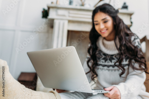 woman in warm sweater working with laptop