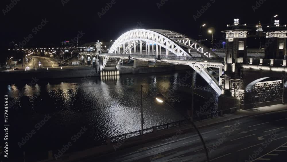 Aerial view of Luzhniki Metro Bridge, also known as Metromost, heavy traffic at night.Moscow river and city skyline during sunset. Big city life concept. Aerial view of Luzhniki Metro Bridge, also known as Metromost, heavy traffic at night.Moscow river and city skyline during sunset. Big city life concept.
