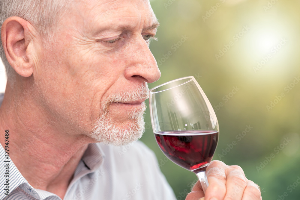 Mature man tasting red wine, light effect Mature man tasting red wine, light effect