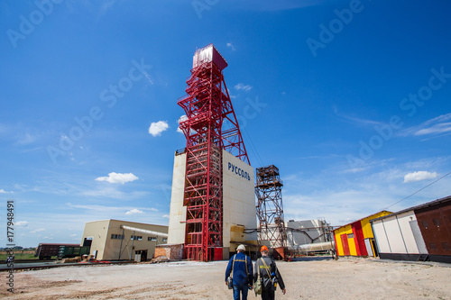 Salt mine headframe with miners at sunny day photo