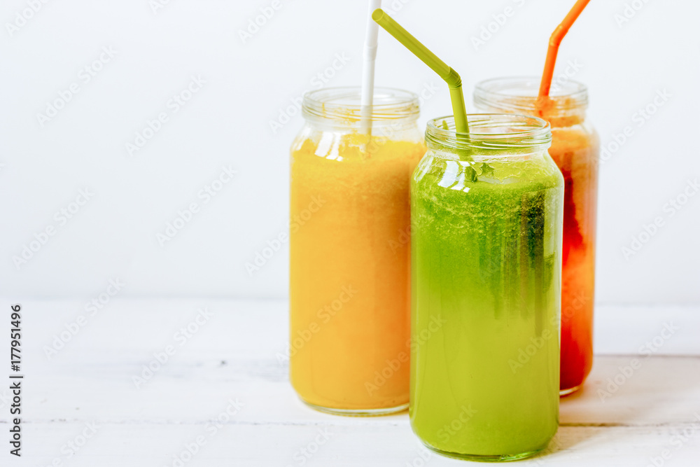 Fresh detox juices in glass bottles on white background Fresh detox juices in glass bottles on white background