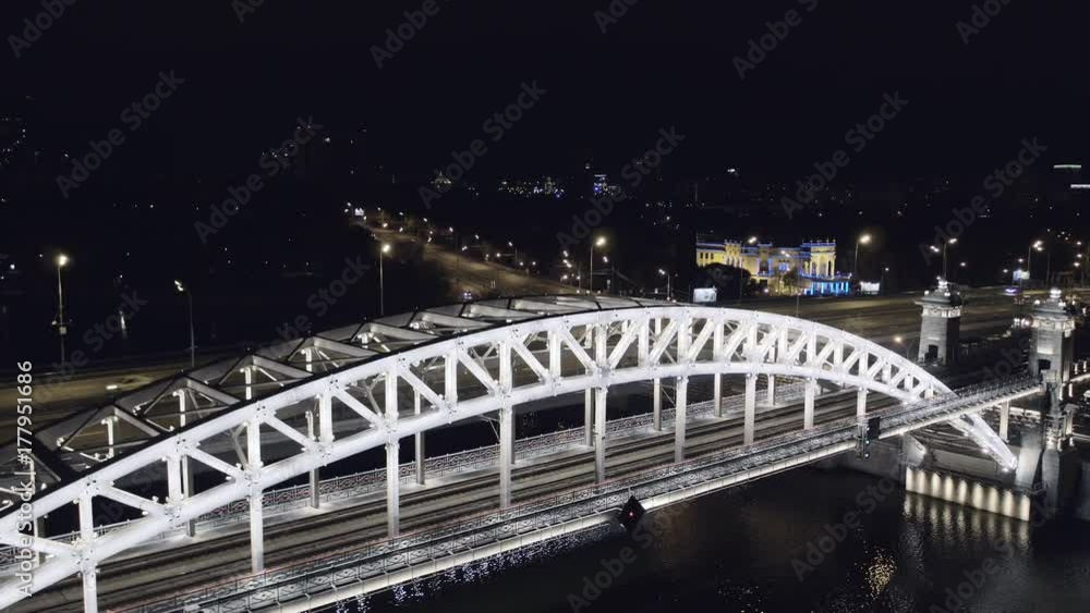 Aerial view of Luzhniki Metro Bridge, also known as Metromost, heavy traffic at night.Moscow river and city skyline during sunset. Big city life concept. Aerial view of Luzhniki Metro Bridge, also known as Metromost, heavy traffic at night.Moscow river and city skyline during sunset. Big city life concept.