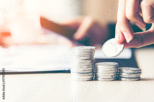 Businessman hand putting stack of coin money cover growing plant for the investment financial report.  Investment concept..