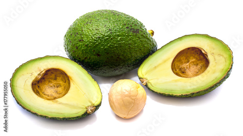 Whole avocado (Persea americana, alligator pear) and its halves with a stone isolated on white background photo