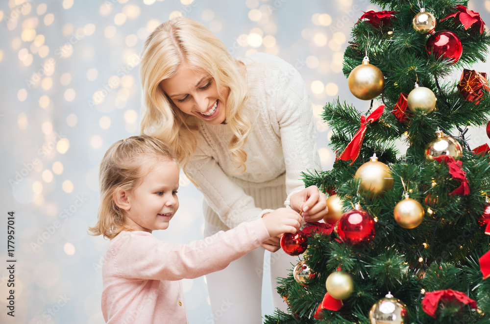 mother and daughter decorating christmas tree mother and daughter decorating christmas tree