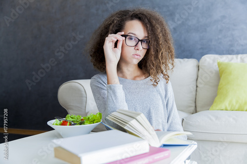 Curly hair teen girl readin...