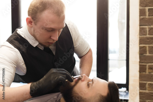 Man getting haircut by hairstylist at barbershop