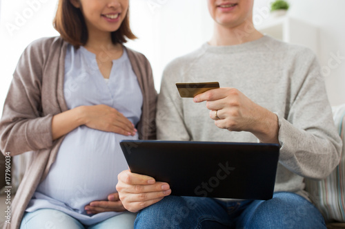 close up of man and pregnant wife shopping online © Syda Productions