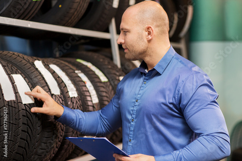 auto business owner and wheel tires at car service © Syda Productions