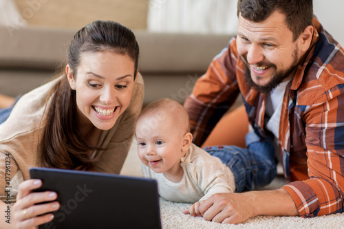 mother, father and baby with tablet pc at home