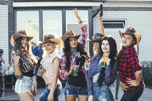 Photography Women young beautiful sensual fun at a party with drinks together in cowboy styl