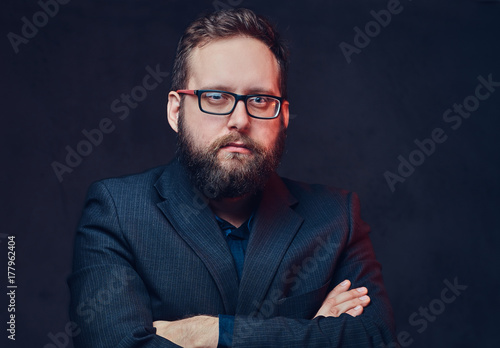 Serious plump male in eyeglasses over grey background.