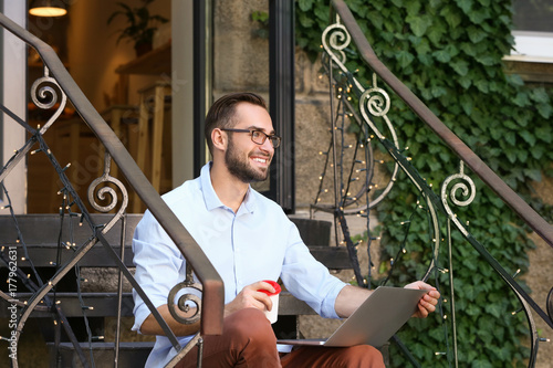 Handsome man with laptop si...