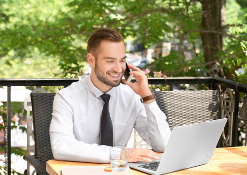 Elegant man with laptop tal...