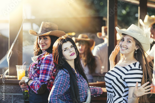 Sticker Women young beautiful sensual fun at a party with drinks together in cowboy styl