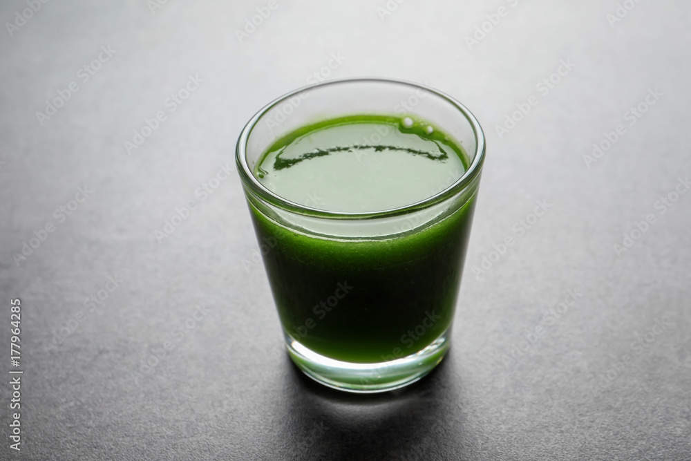 Shot of healthy wheat grass juice on grey background Shot of healthy wheat grass juice on grey background