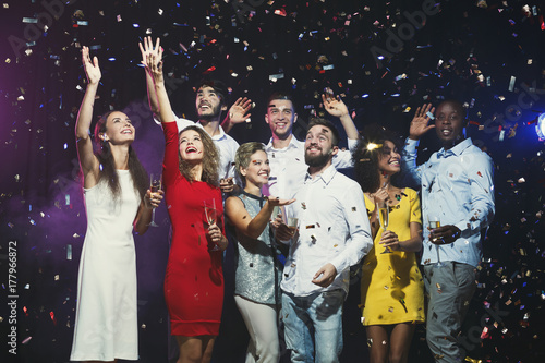 Happy young friends celebrating christmas at night club